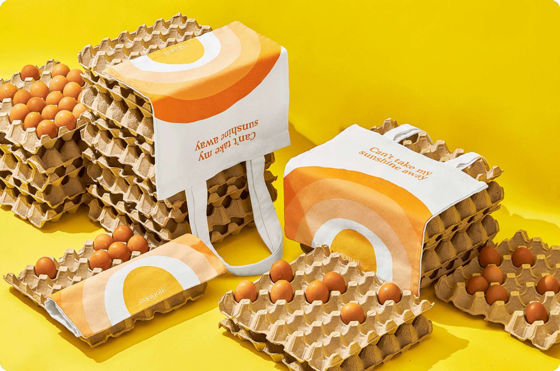 Eggyolk sunrise tote bags among trays of fresh eggs
