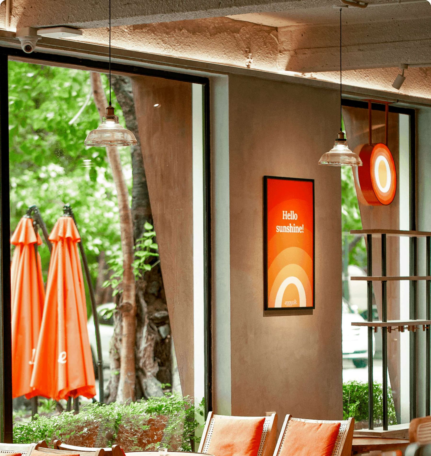 A Hello sunshine poster beside tall windows framing green trees